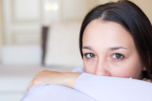 woman peering over her folded arms considering entering a Meth Addiction Treatment Center