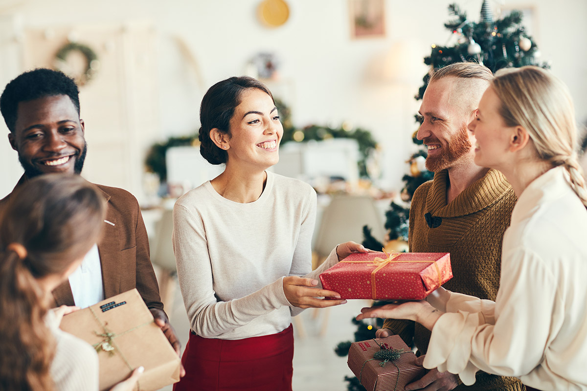 a group of people exchange gifts during sober holidays
