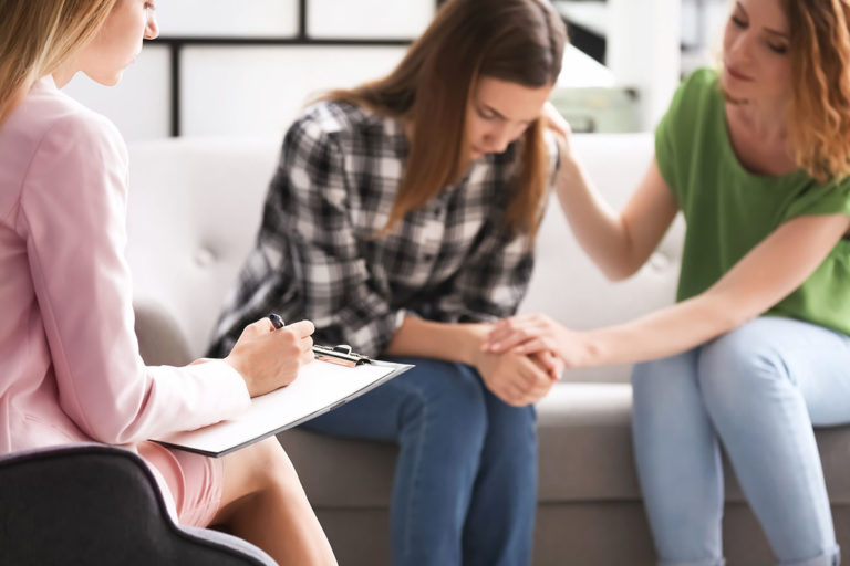 Young woman and her teenage daughter visiting child psychologist a woman provides her loved one with support in addiction treatment