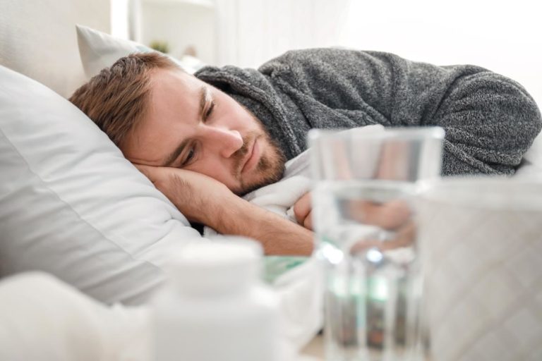 How Long Does Heroin Detox Last For a man lays in bed thinking about heroin addiction help and heroin treatment options before seeking a heroin detox program