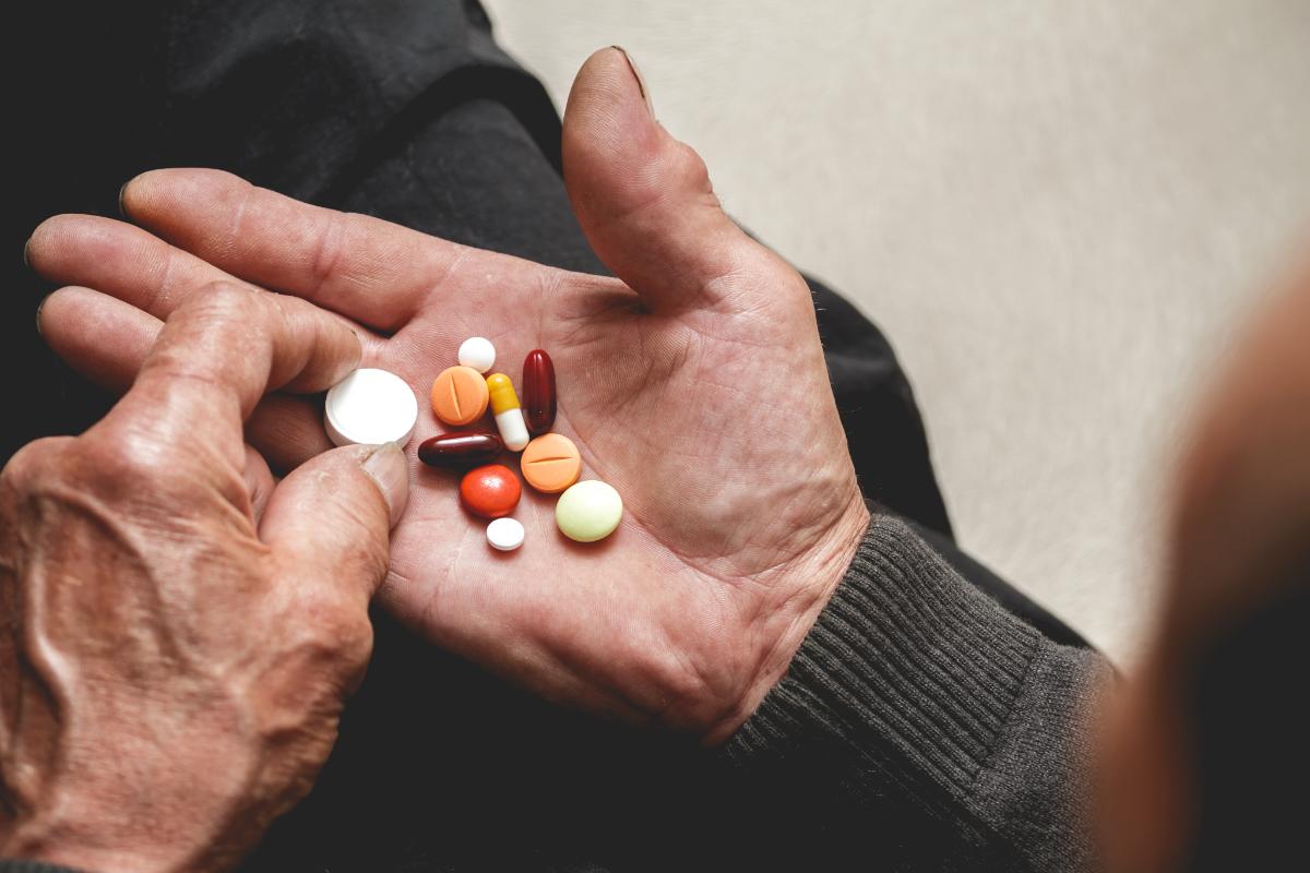 3 Signs You’re Addicted to Prescription Medication pills in a mans hands