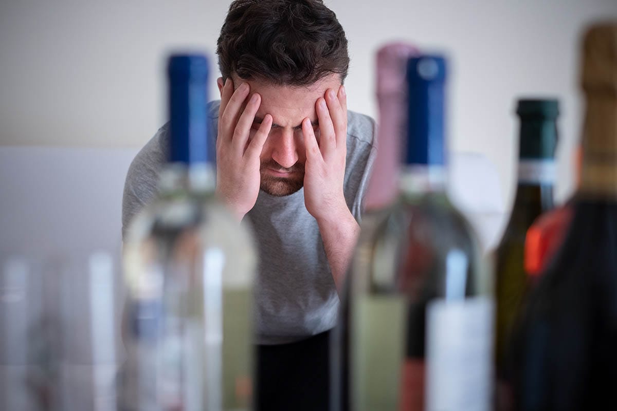 What Are the Signs of Alcohol Abuse_ man with wine bottles