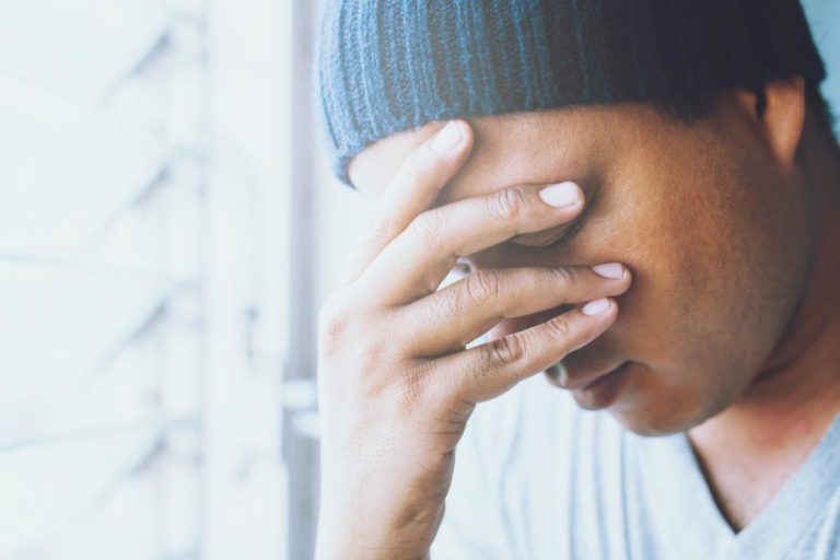 5 Signs of Benzo Addiction a man covers his face as he considers the signs of benzo addiction
