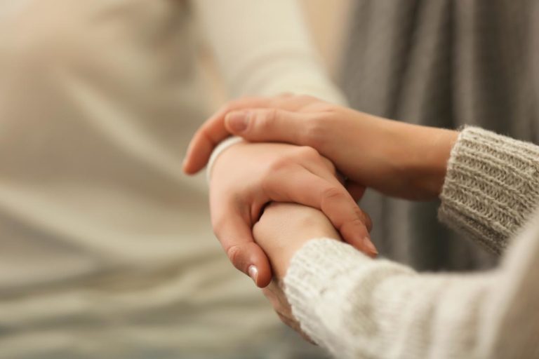 How to Know When its Time to Get Help For Meth Addiction a woman holds the hand of another woman as they discuss what is meth addiction