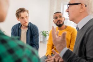 group discussing a men's rehab program